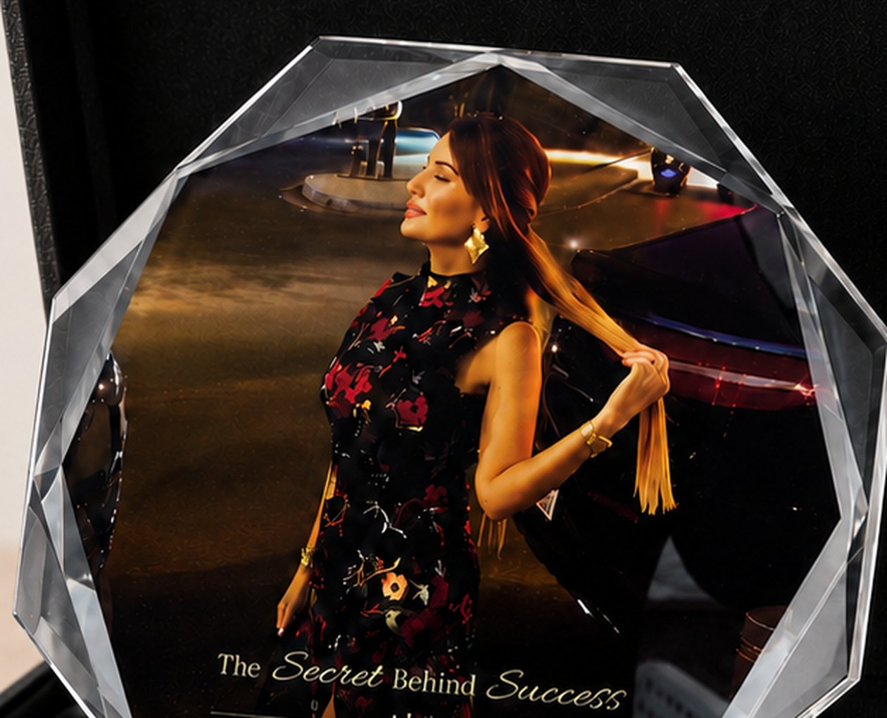 Close detail of a crystal award printed in full colour with a photograph and gold script lettering