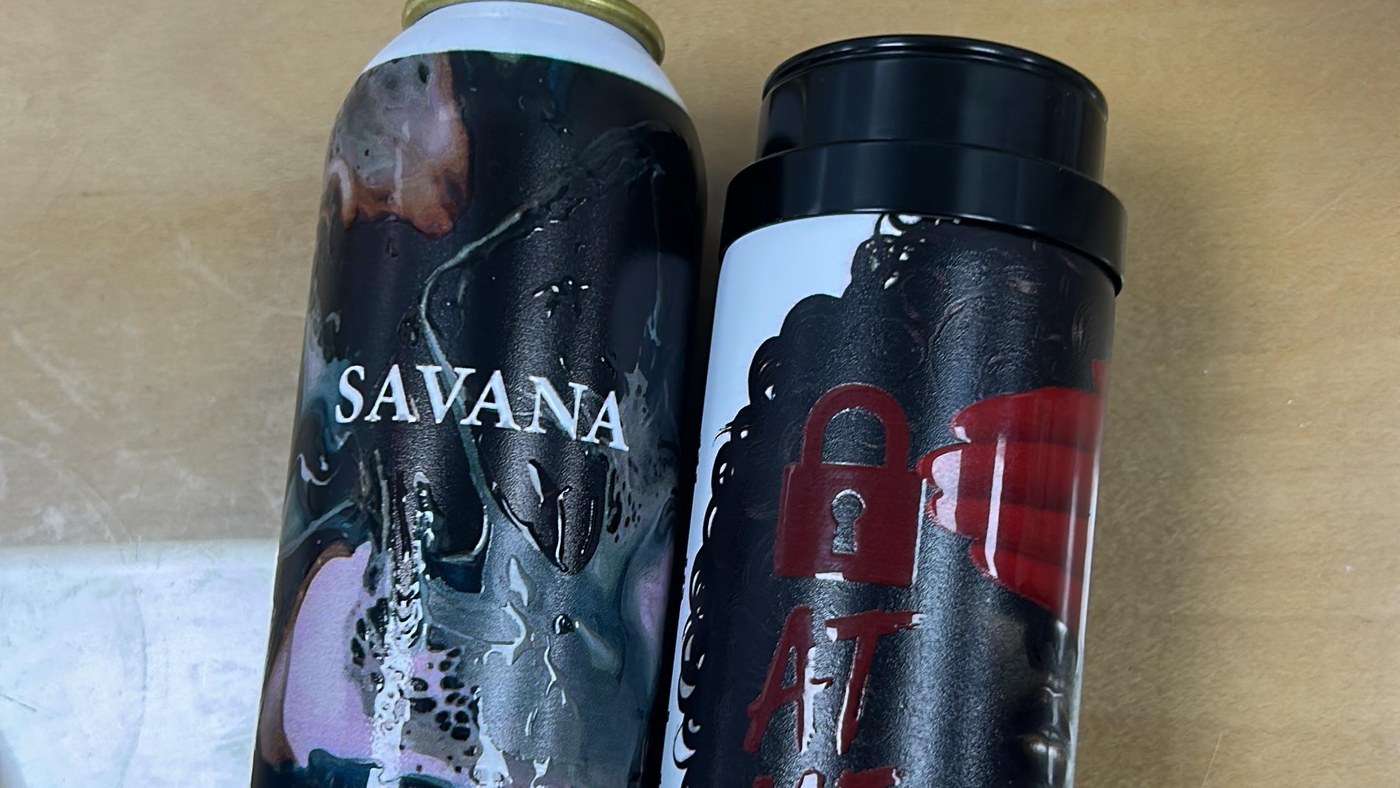 Two printed aluminium body spray cans with high gloss raised detail over dark artwork