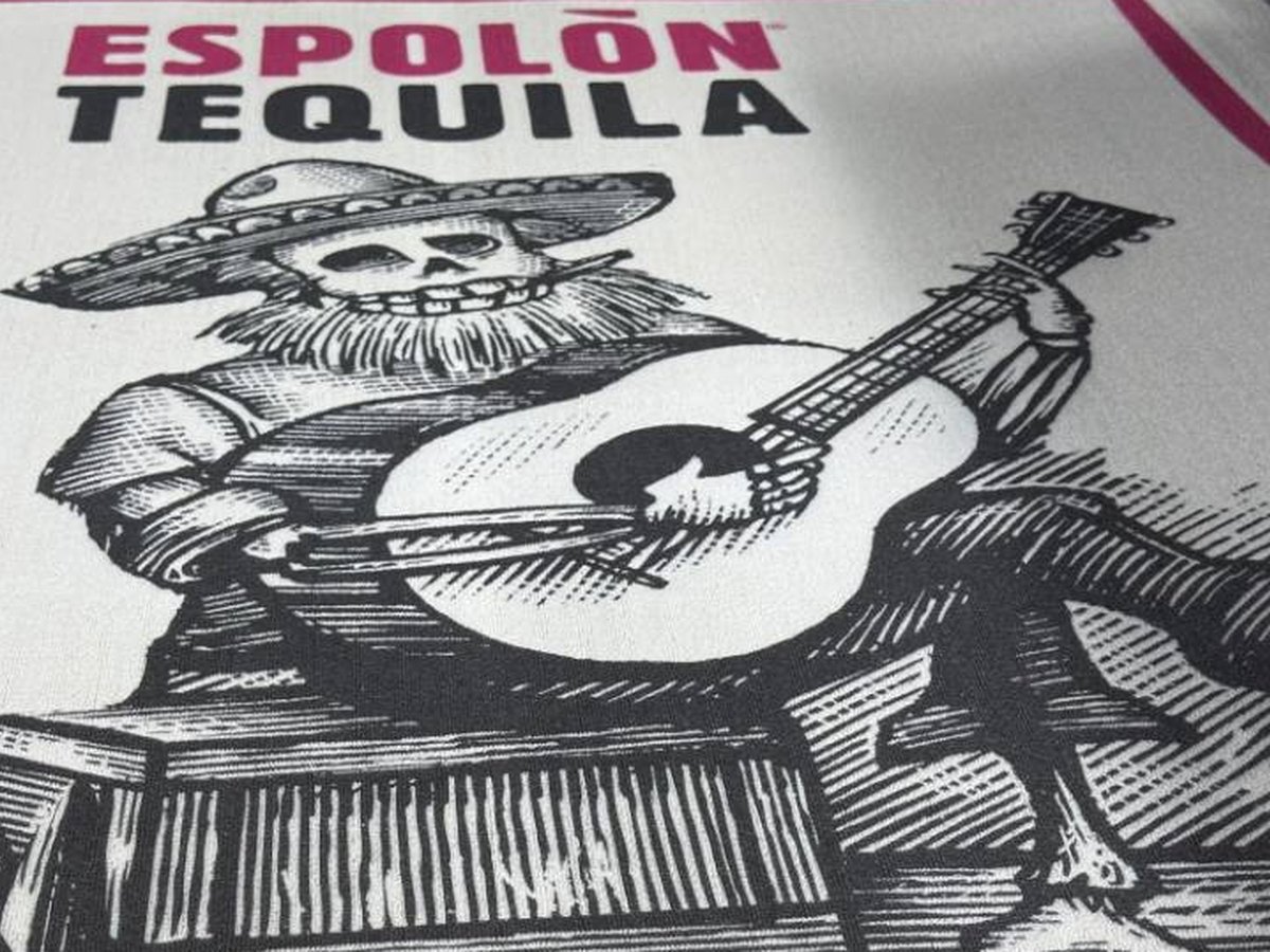لقطة قريبة للوبر المطبوع تُظهر الهيكل العظمي بالتظليل المتقاطع وحروف Espolòn Tequila، مع ظهور الألياف الكريمية بين الخطوط السوداء
