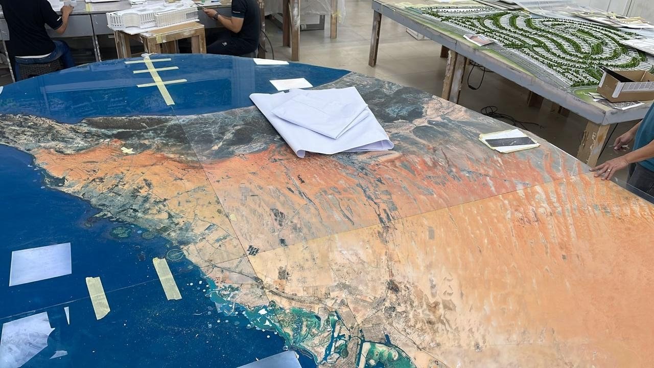 The printed acrylic base in the model workshop, with the Gulf coastline and desert terrain running across the panel