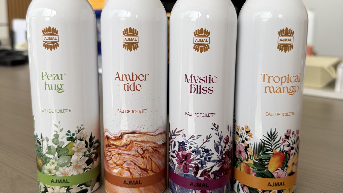 Four aluminium body spray cans printed full wrap with four different fragrance designs, standing side by side
