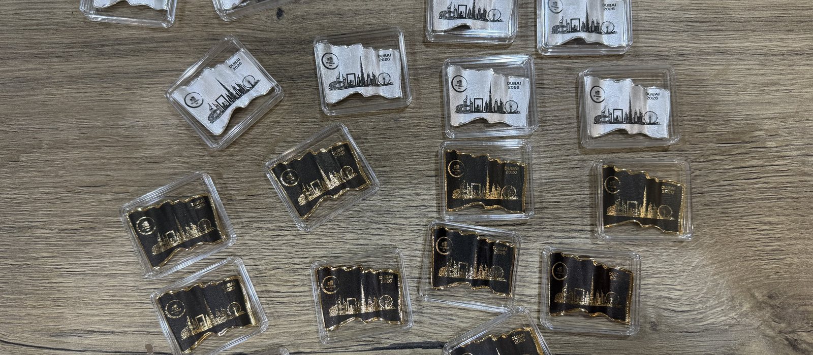 Gold and silver commemorative pieces with a waving profile, printed with a Dubai skyline