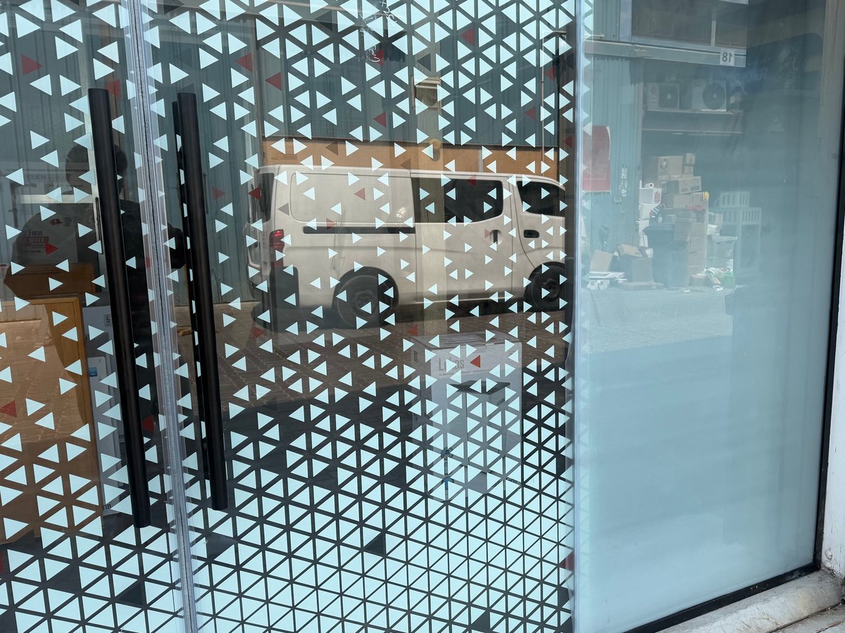 Where a printed sliding leaf meets the fixed side panel, the panel fading from clear at eye level to solid white lower down