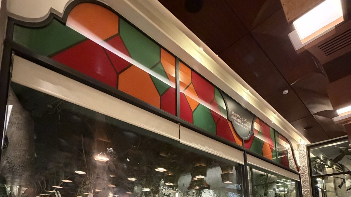 The printed coloured glass band running above the window wall of the Um Khalil dining room in Amman