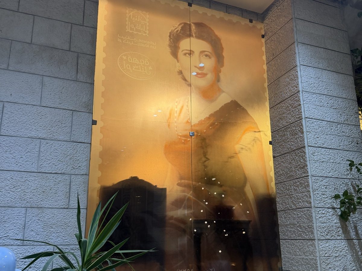 A large printed glass portrait of Antoinette Rami, uplit and standoff-fixed to the stone wall