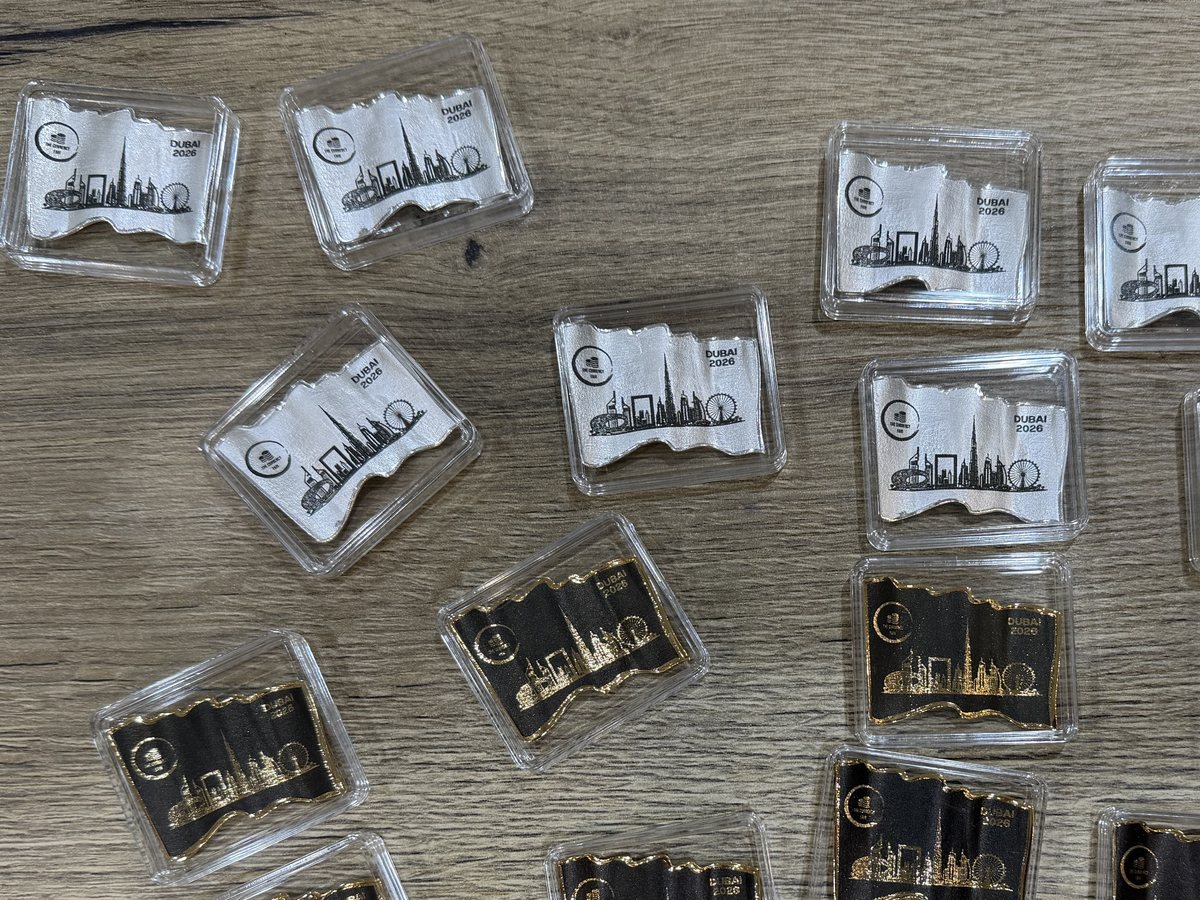 Silver commemorative pieces with a Dubai skyline printed in black across the bright face