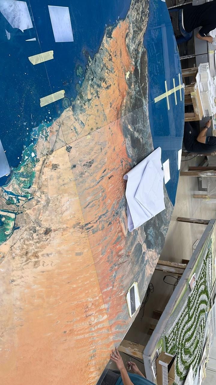 The printed acrylic base in the model workshop, with the Gulf coastline and desert terrain running across the panel