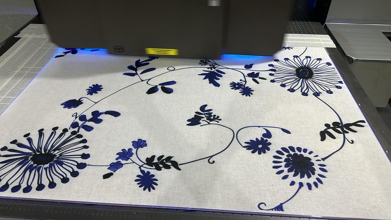 Natural linen printed with an indigo floral design on the flatbed at Sun Studio Dubai