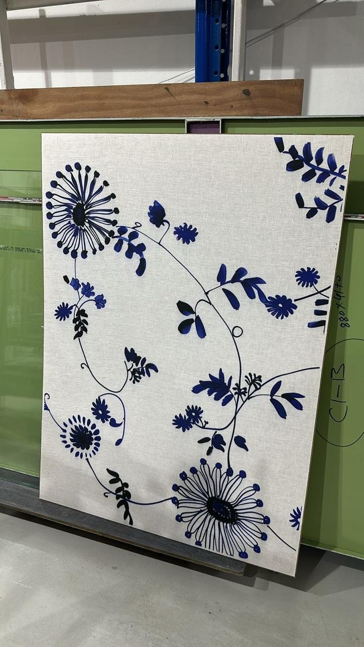 A printed linen panel in the studio, indigo florals on natural cloth, ready for framing