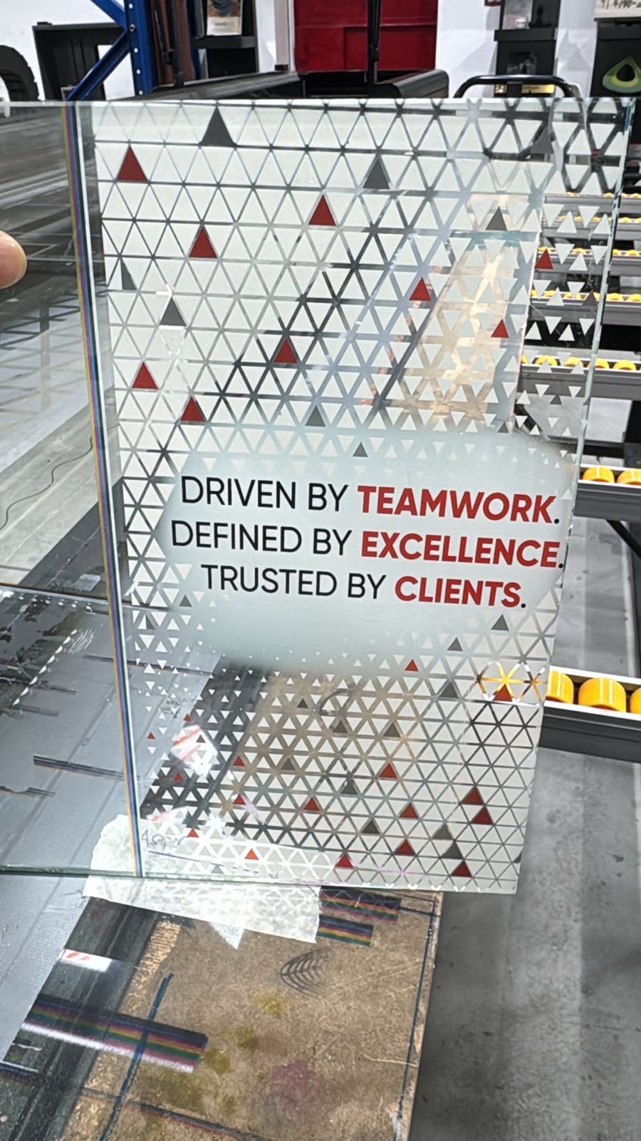 A printed glass panel with a pattern and a white-backed text block