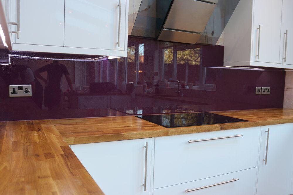 A teal splashback fitted around sockets and an oven housing