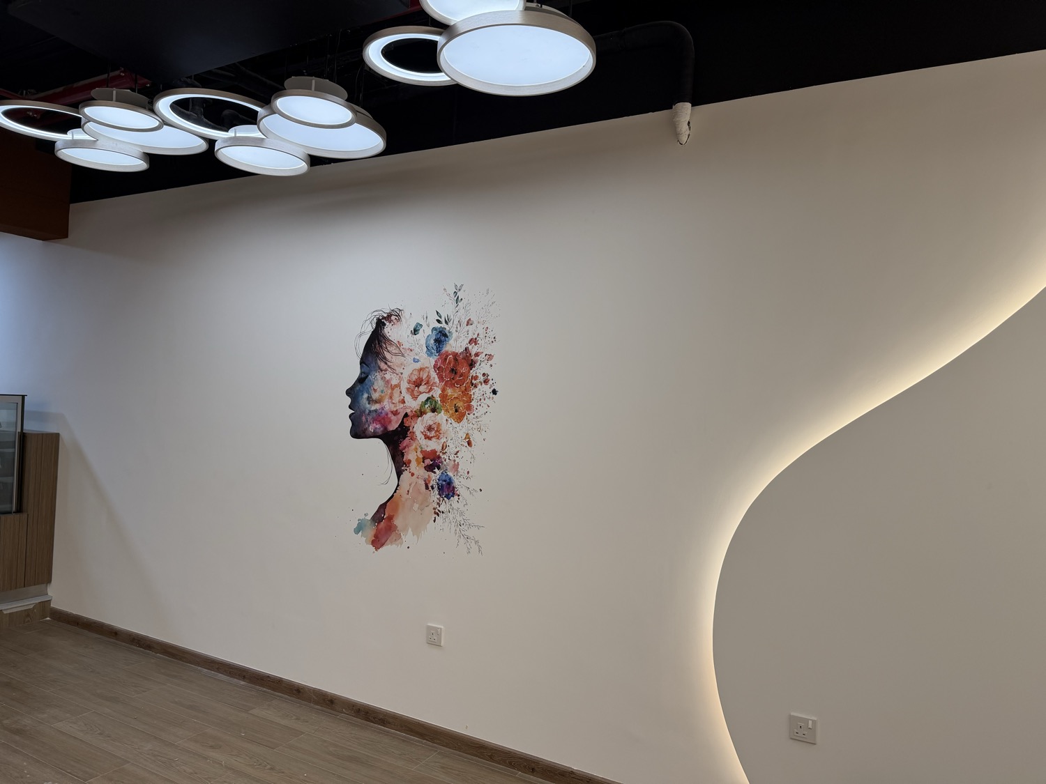 Watercolour artwork printed on a curved feature wall in the ladies’ studio