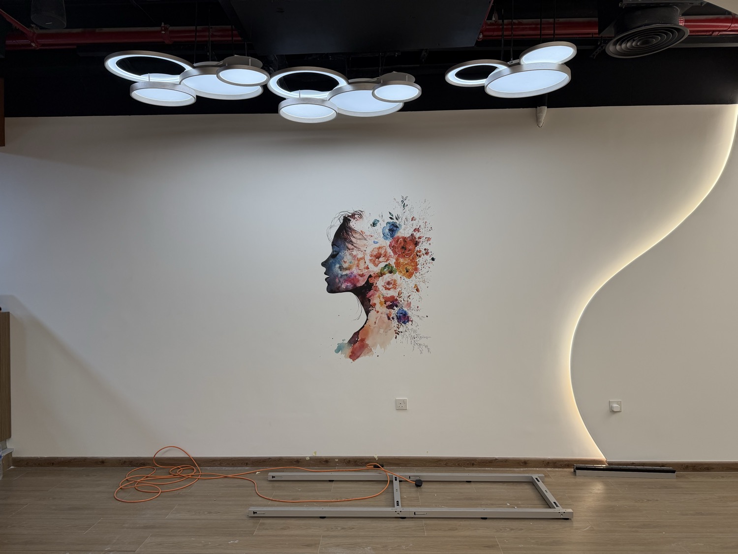 Printed wall artwork beside the studio’s backlit feature wall at Body Abs Gym
