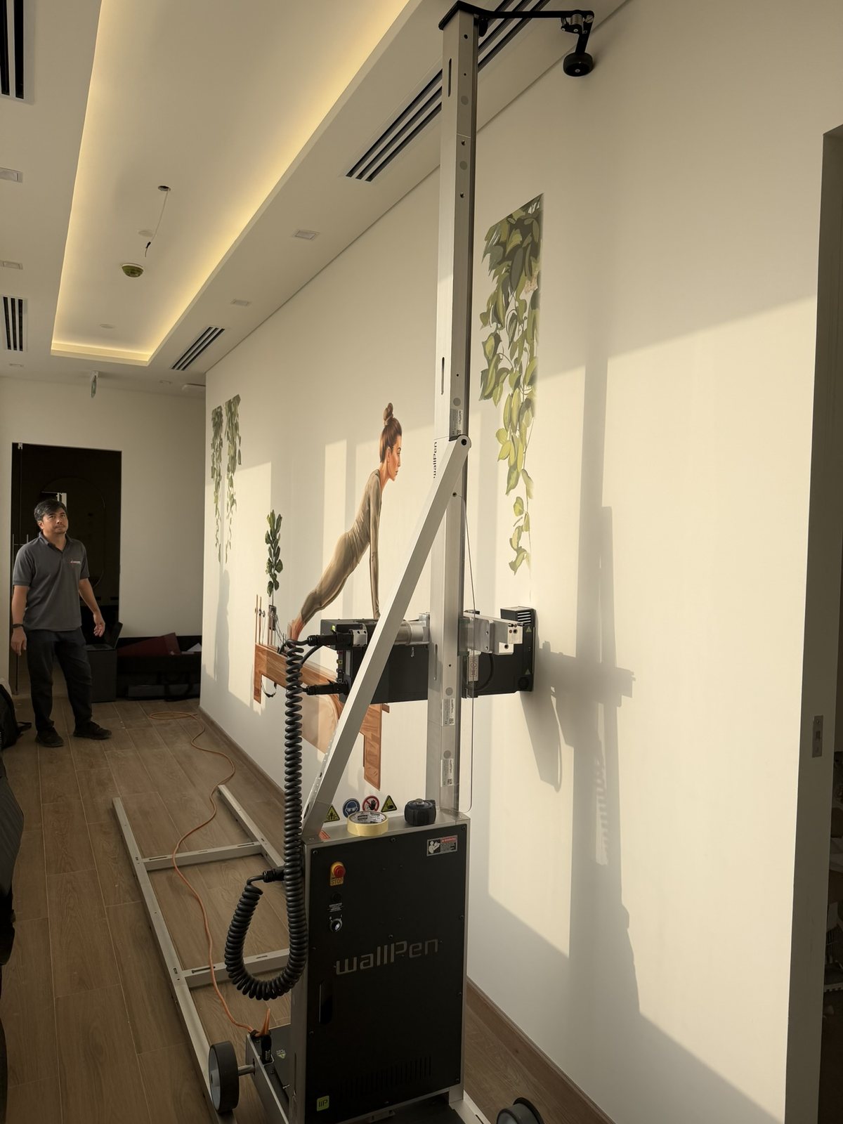 The wallPen laying ink onto the studio wall, printing a yoga figure in place