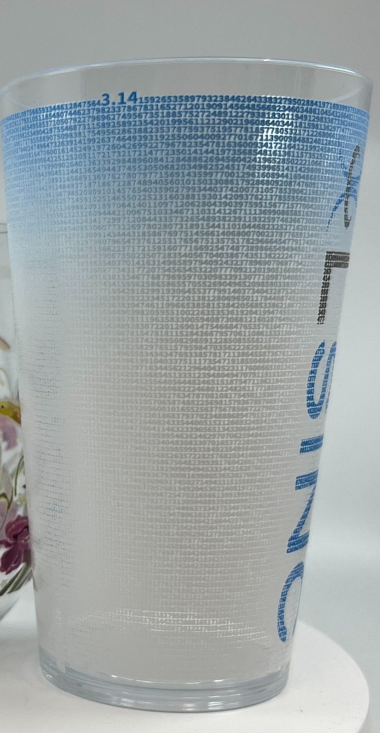 A glass cup printed with fine text at Sun Studio Dubai