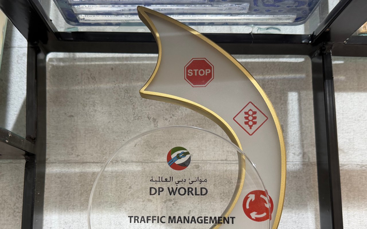 A gold-edged white wave award printed with stop, traffic-light and roundabout signs, with DP World and Traffic Management on a clear disc