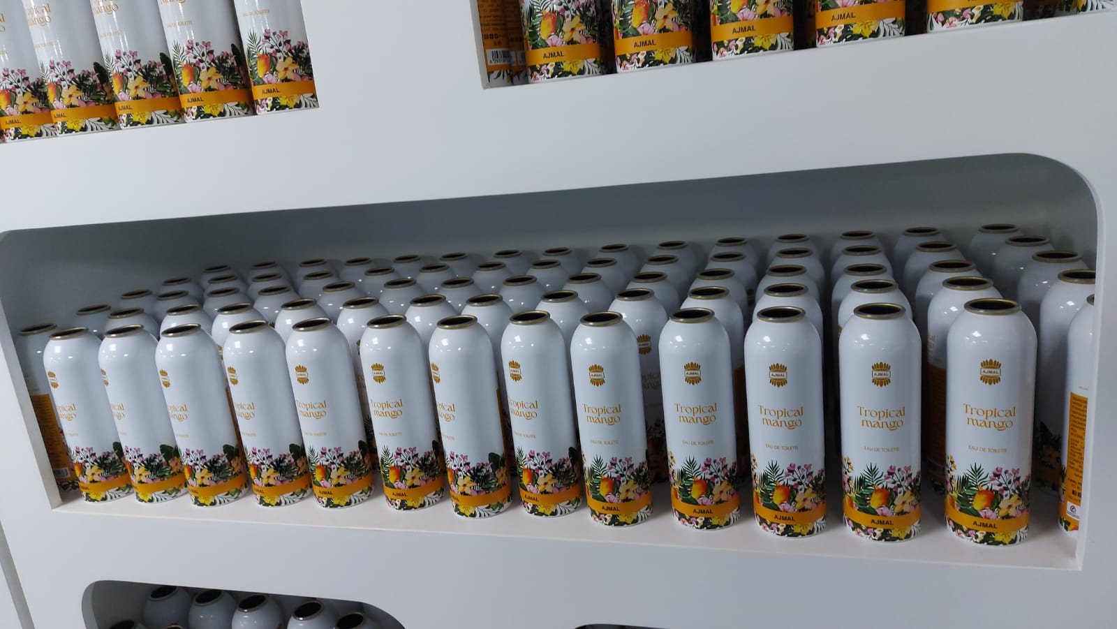 صفوف من عبوات الألمنيوم لعطر Tropical Mango من Ajmal على رف بعد الطباعة المباشرة على طابعة LSINC PeriQ360