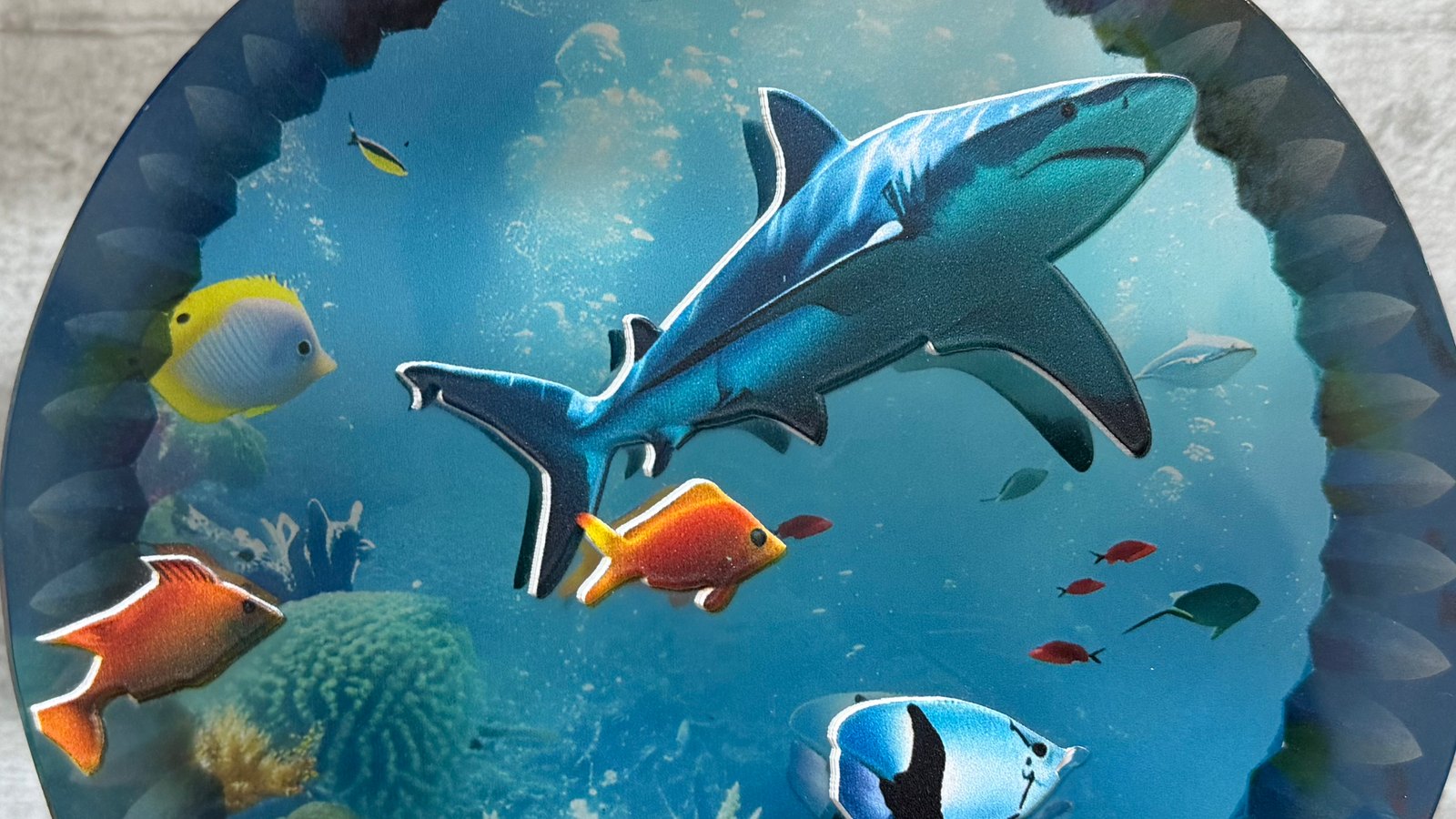 Close-up of a shark and reef fish printed in full colour on a K9 crystal block, the shark and the larger fish outlined in white